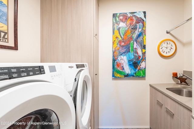 clothes washing area featuring sink and separate washer and dryer