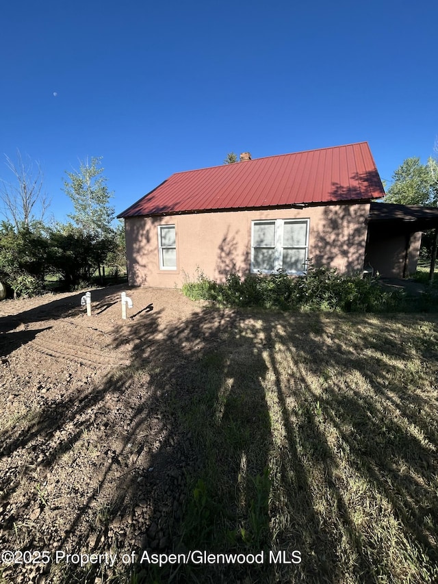 16125 57 8/10 Rd, Collbran, CO 81624 - view of side of home with stucco siding and a metal roof