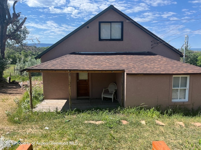 16125 57 8/10 Rd, Collbran, CO 81624 - back of house featuring a shingled roof and stucco siding