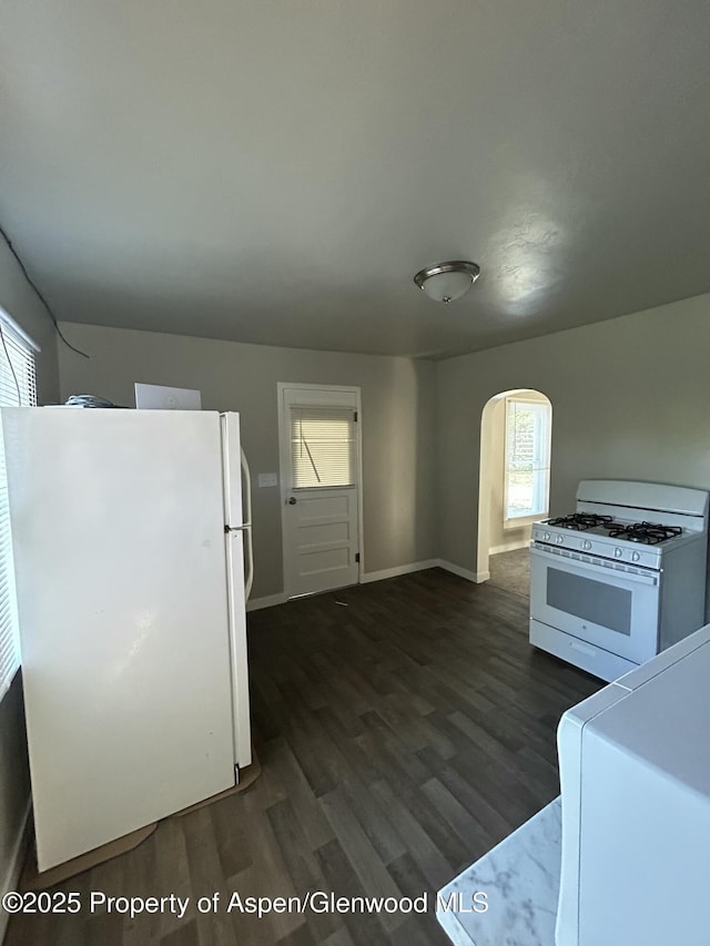 16125 57 8/10 Rd, Collbran, CO 81624 - kitchen with white appliances, arched walkways, dark wood finished floors, and healthy amount of natural light