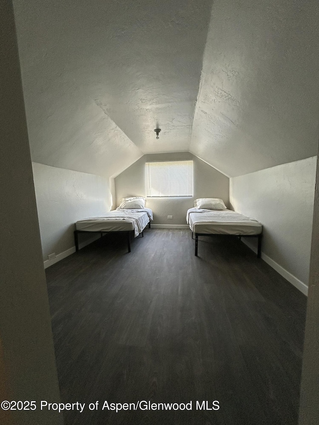 16125 57 8/10 Rd, Collbran, CO 81624 - bedroom featuring a textured ceiling, lofted ceiling, and wood finished floors