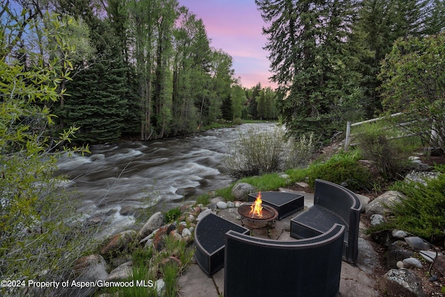 patio terrace at dusk featuring a fire pit