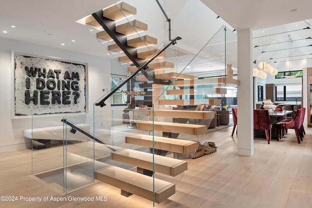 stairway featuring plenty of natural light and wood-type flooring