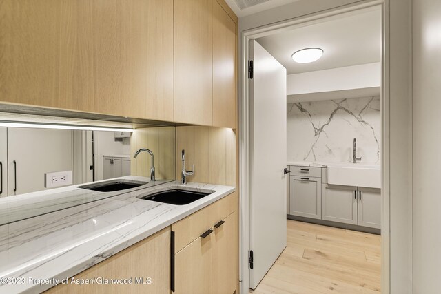 laundry room featuring light hardwood / wood-style floors and sink