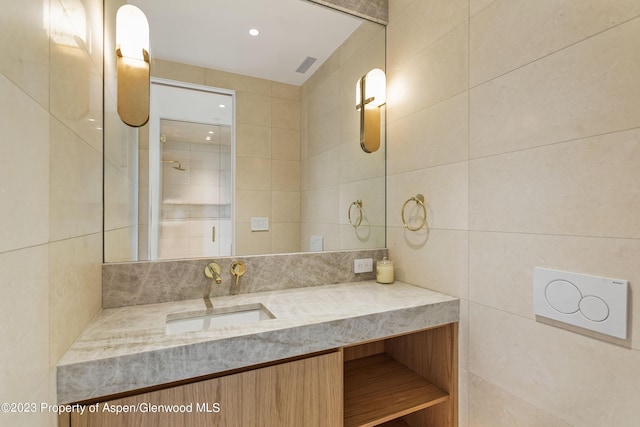 bathroom featuring vanity and tile walls