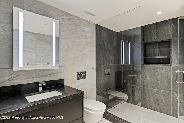 bathroom with toilet, vanity, tile walls, and walk in shower