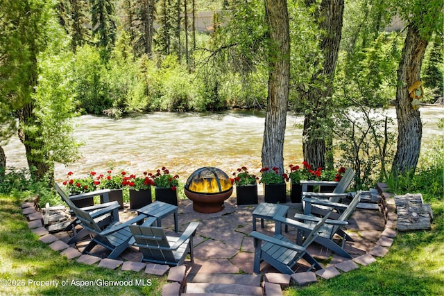 view of patio / terrace featuring a water view and a fire pit