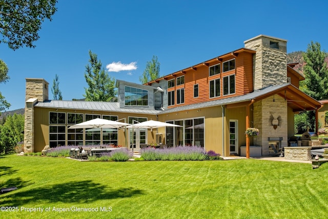 rear view of house with a lawn and a patio