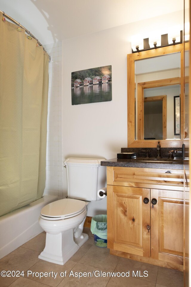 full bathroom featuring tile patterned flooring, vanity, toilet, and shower / tub combo with curtain