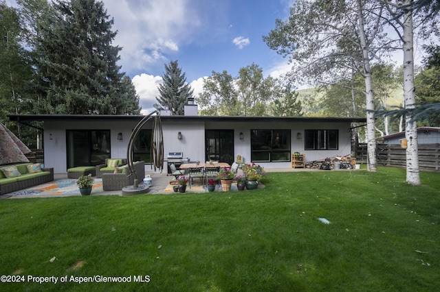 rear view of house with a yard, a patio, and an outdoor hangout area