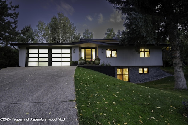 view of front of home with a garage and a yard