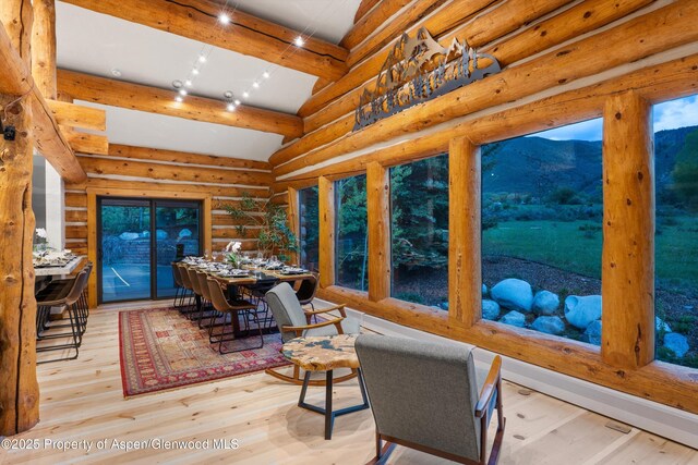 2134 Lower River Rd, Snowmass, CO 81654 - dining space featuring hardwood / wood-style floors, beamed ceiling, log walls, and a mountain view