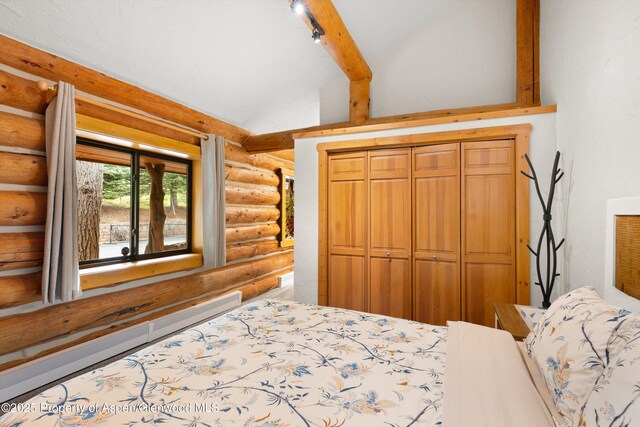 2134 Lower River Rd, Snowmass, CO 81654 - bedroom featuring rustic walls, a baseboard heating unit, vaulted ceiling, and a closet