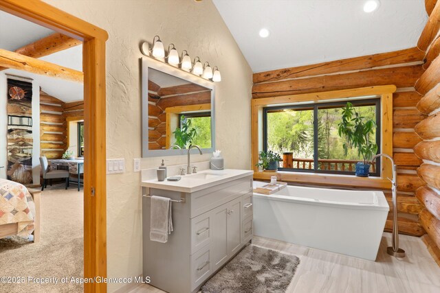 2134 Lower River Rd, Snowmass, CO 81654 - bathroom featuring rustic walls, lofted ceiling, a soaking tub, vanity, and recessed lighting