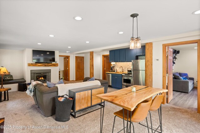 2134 Lower River Rd, Snowmass, CO 81654 - living room featuring recessed lighting, a warm lit fireplace, bar, and light carpet
