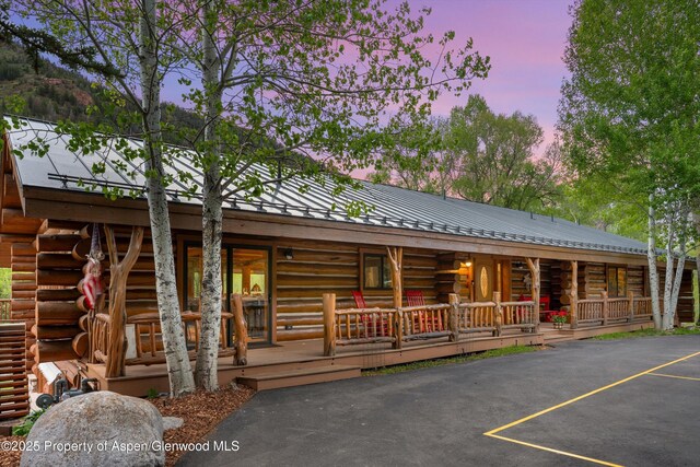 2134 Lower River Rd, Snowmass, CO 81654 - log home with log siding, a porch, uncovered parking, and metal roof