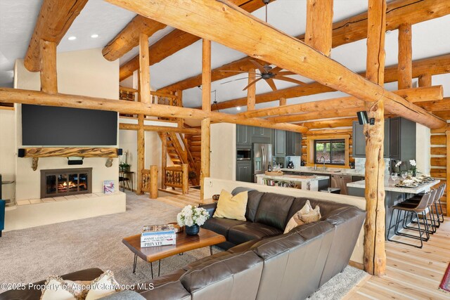 2134 Lower River Rd, Snowmass, CO 81654 - living room featuring stairs, beam ceiling, log walls, high vaulted ceiling, and recessed lighting