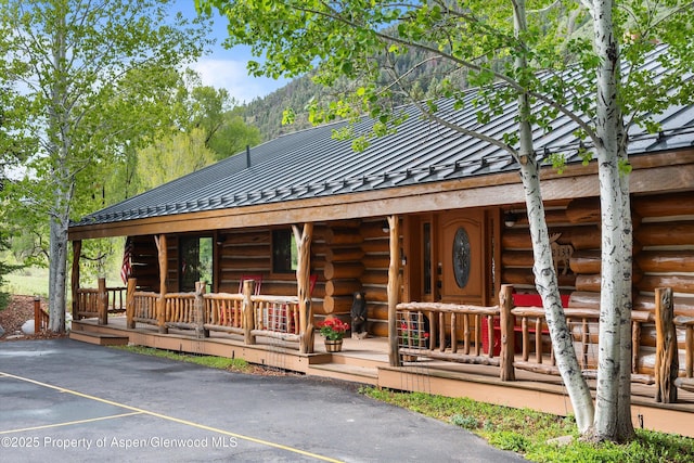 2134 Lower River Rd, Snowmass, CO 81654 - log-style house featuring log siding, a standing seam roof, uncovered parking, metal roof, and covered porch