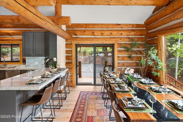2134 Lower River Rd, Snowmass, CO 81654 - kitchen with a sink, plenty of natural light, gray cabinetry, light wood-type flooring, and log walls