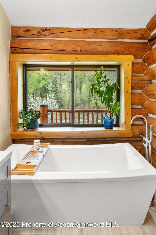 2134 Lower River Rd, Snowmass, CO 81654 - full bathroom featuring rustic walls and a freestanding tub