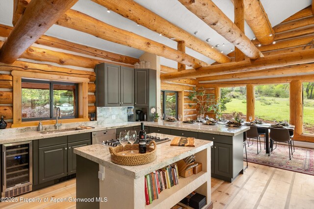 2134 Lower River Rd, Snowmass, CO 81654 - kitchen featuring wine cooler, gray cabinetry, a sink, rustic walls, and a kitchen island