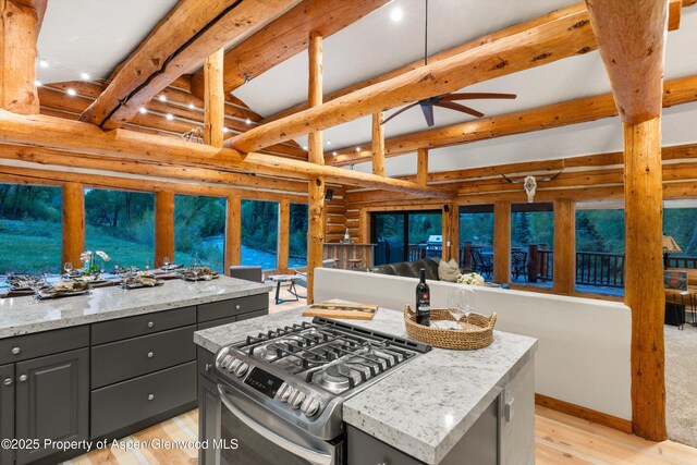 2134 Lower River Rd, Snowmass, CO 81654 - kitchen featuring beamed ceiling, stainless steel gas range oven, gray cabinets, rustic walls, and light wood-style flooring