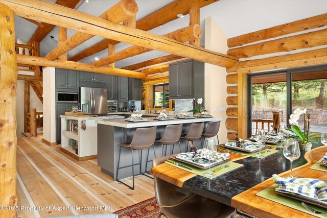 2134 Lower River Rd, Snowmass, CO 81654 - kitchen with appliances with stainless steel finishes, gray cabinets, plenty of natural light, and rustic walls
