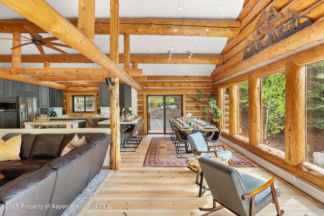 2134 Lower River Rd, Snowmass, CO 81654 - living room with light wood-style flooring, rustic walls, and a ceiling fan