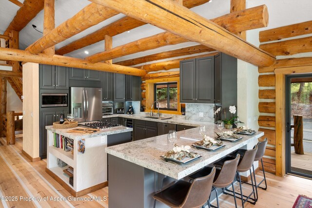 2134 Lower River Rd, Snowmass, CO 81654 - kitchen featuring stainless steel appliances, gray cabinetry, beamed ceiling, a sink, and light stone counters