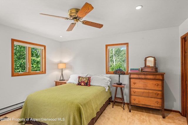 carpeted bedroom with multiple windows, a baseboard heating unit, recessed lighting, and baseboards