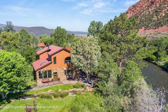 birds eye view of property featuring a wooded view and a mountain view