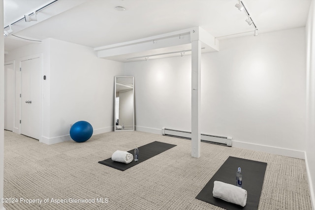 workout room featuring track lighting, light carpet, and a baseboard heating unit