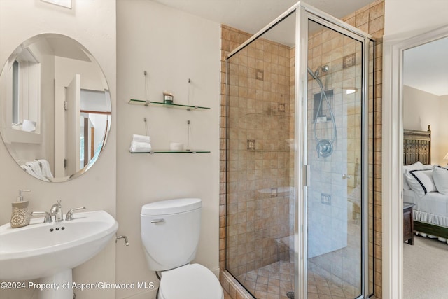 bathroom with toilet, a shower with door, and sink