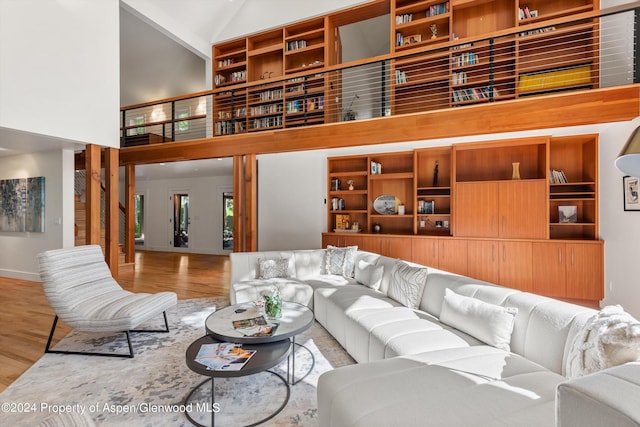 living room with hardwood / wood-style flooring and high vaulted ceiling