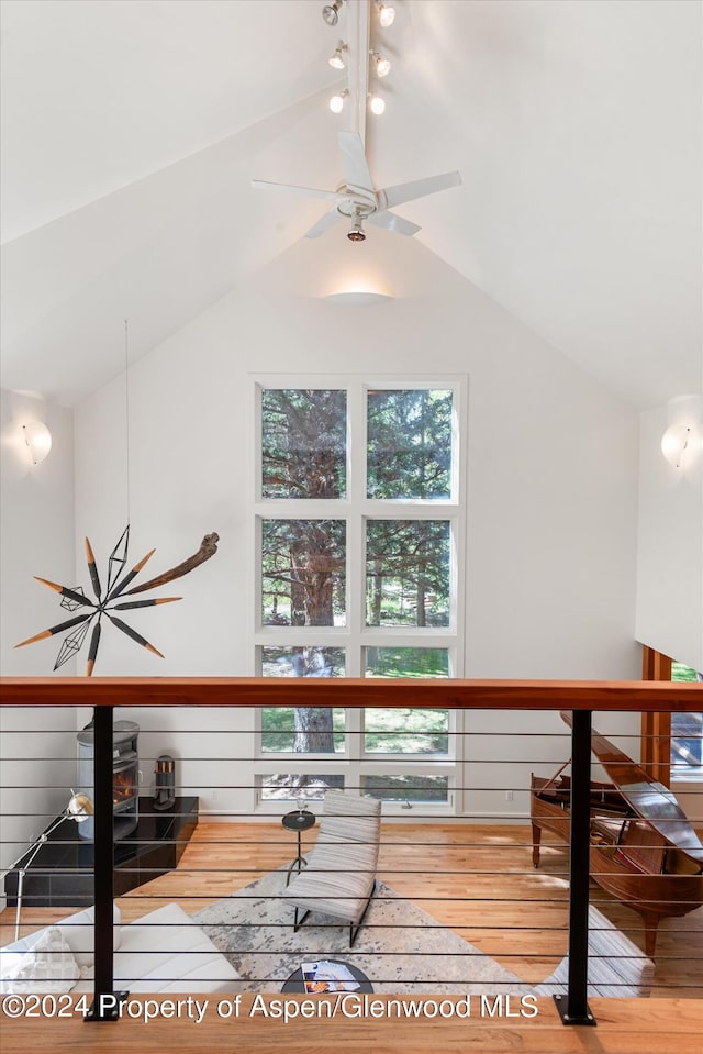 interior space featuring hardwood / wood-style flooring, a wood stove, ceiling fan, and lofted ceiling