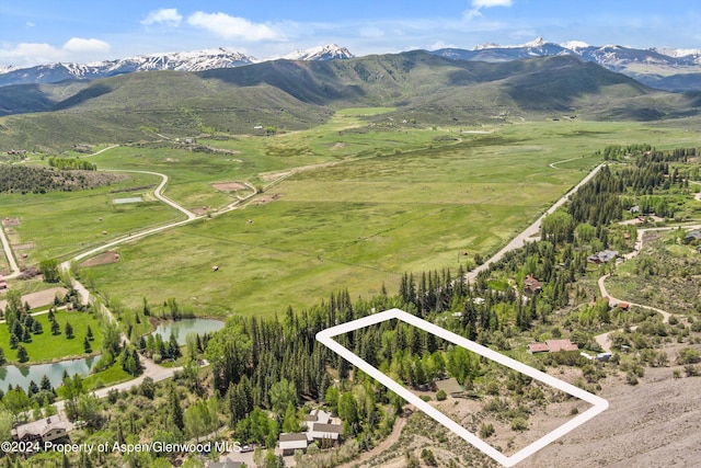 drone / aerial view featuring a water and mountain view