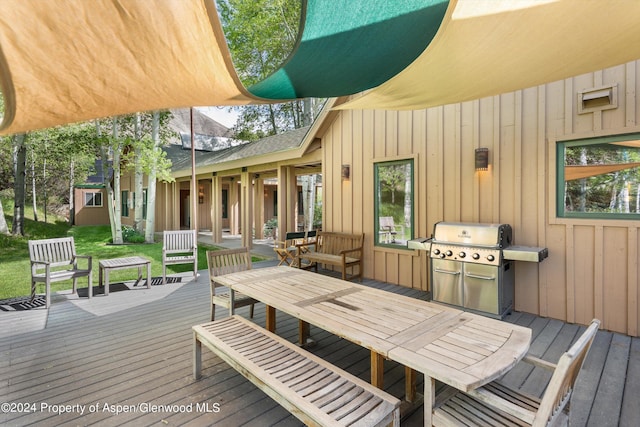 wooden terrace with a grill and an outbuilding