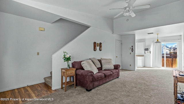 carpeted living room with a ceiling fan, lofted ceiling, stairway, and baseboards