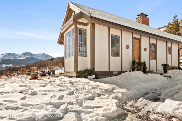 view of snow covered exterior featuring a mountain view