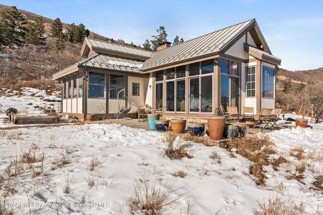 snow covered property with a sunroom