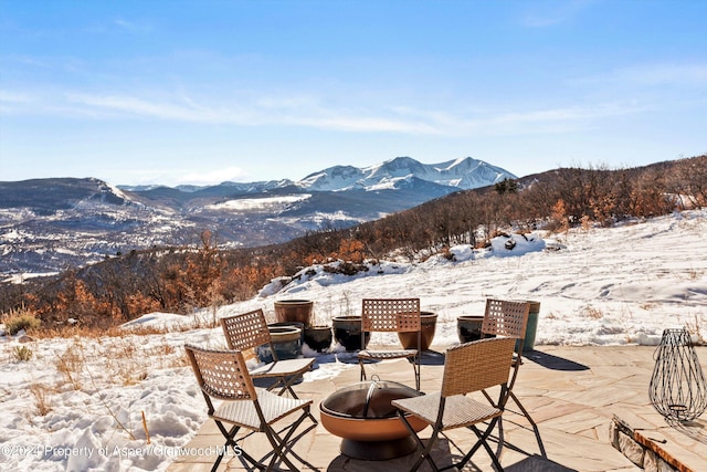 snow covered patio with a mountain view