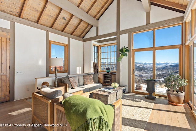 living room with a mountain view, hardwood / wood-style floors, high vaulted ceiling, and wood ceiling