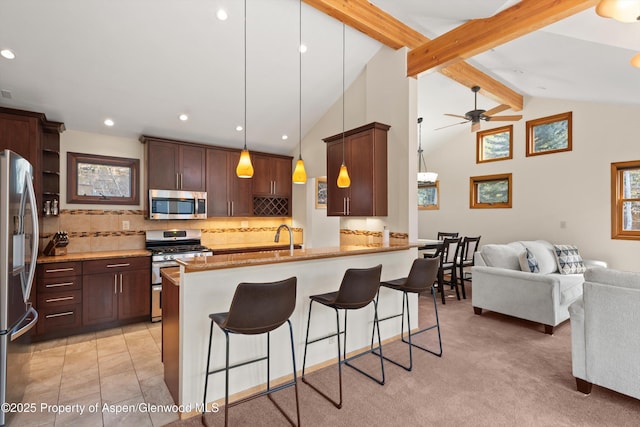 536 Spruce St, Aspen, CO 81611 - kitchen featuring lofted ceiling with beams, a kitchen breakfast bar, stainless steel appliances, open floor plan, and decorative backsplash