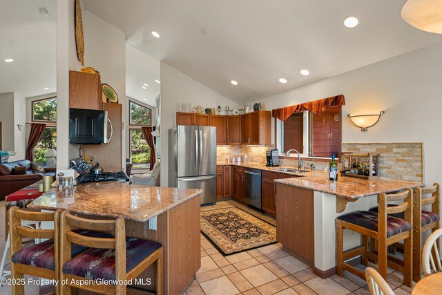 10 Cedar Cv, Glenwood Springs, CO 81601 - kitchen with stainless steel appliances, a peninsula, decorative backsplash, recessed lighting, and a breakfast bar