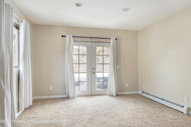 carpeted empty room featuring french doors, baseboards, and baseboard heating