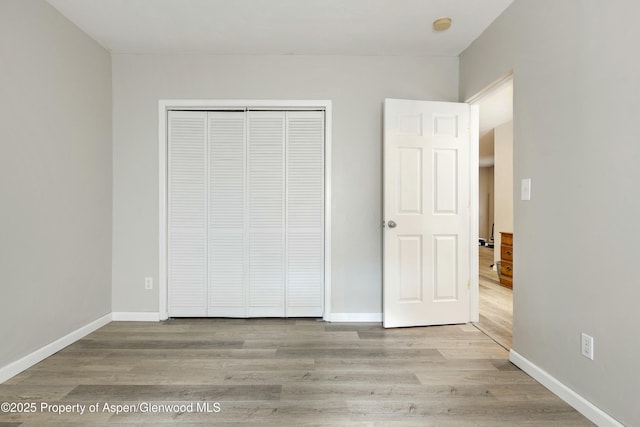 unfurnished bedroom with baseboards and wood finished floors