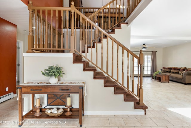 stairs with tile patterned floors, baseboards, and ceiling fan