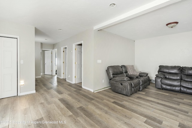 living area with baseboard heating, baseboards, and light wood finished floors