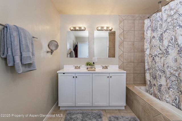 full bath featuring tile patterned floors, tiled shower / bath, double vanity, and a sink