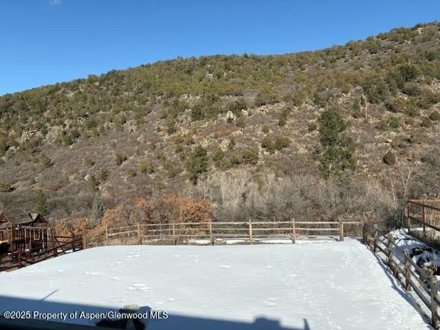 view of yard featuring a forest view and fence